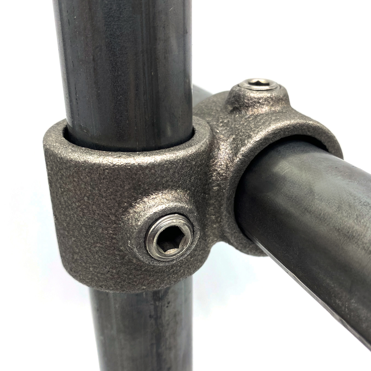 Dark grey, textured cross-piece type 161-A securely connects two bare metal tubes at a 90-degree angle. The vertical and horizontal bars are firmly secured in the robust clamp. Visible Allen screws in cast metal. Natural finish.