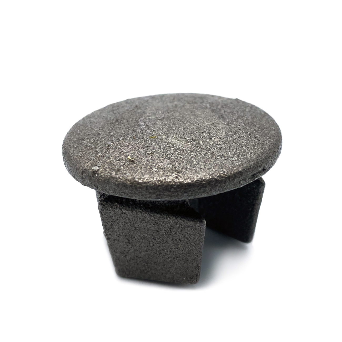 Round metal plug in dark grey with a flat, slightly rough surface, isolated against a white background. Diameter approx. 33.7 mm, with four short, rectangular retaining clips at the bottom. Coarse metal texture visible.