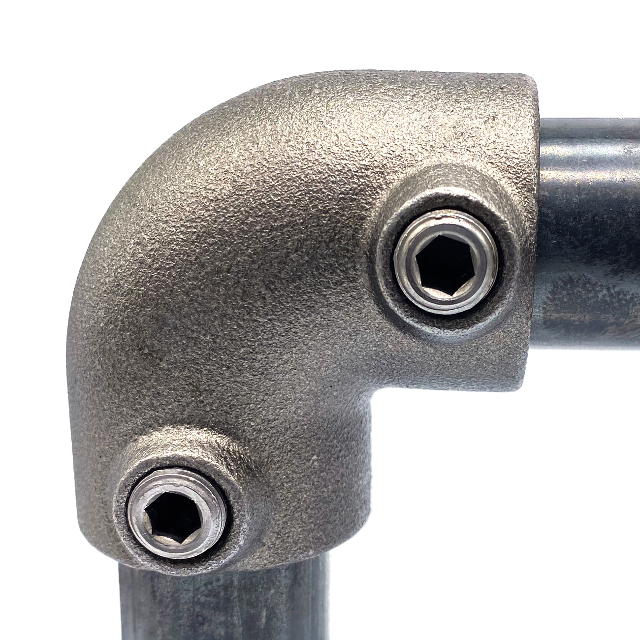 A grey, robust 90-degree metal elbow that connects two pipes and allows for a change of direction. Coarsely textured surface; silver hexagon head screws at both ends for securing the pipes. Close-up view.