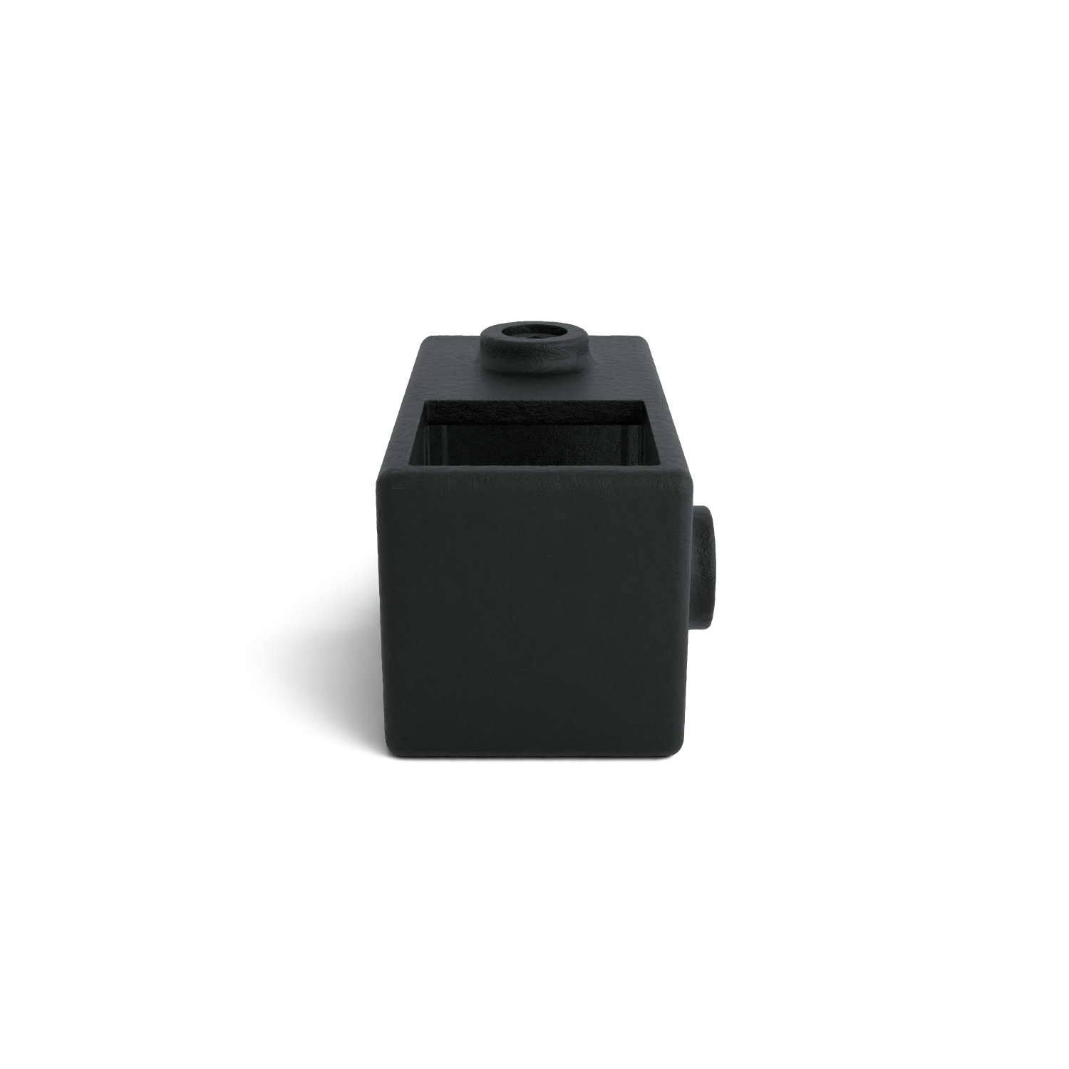 Black, rectangular cast iron component with a rough texture, centered on a white background. At the top, a square opening with a round cap. On the right, a cylindrical spigot protrudes for connection. Shadow at the back left.