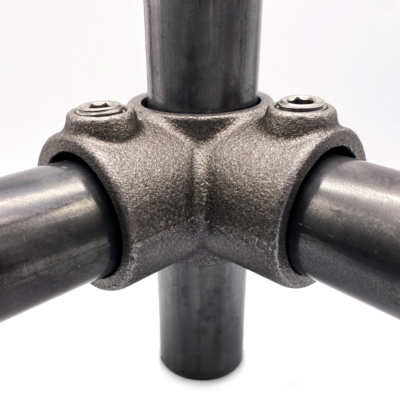 Dark grey, textured metal corner joint connecting three pipes at a 90-degree angle. Two pipes run horizontally and one vertically through the solid 33.7 mm fitting clamp. Silver Allen screws visible at the top.